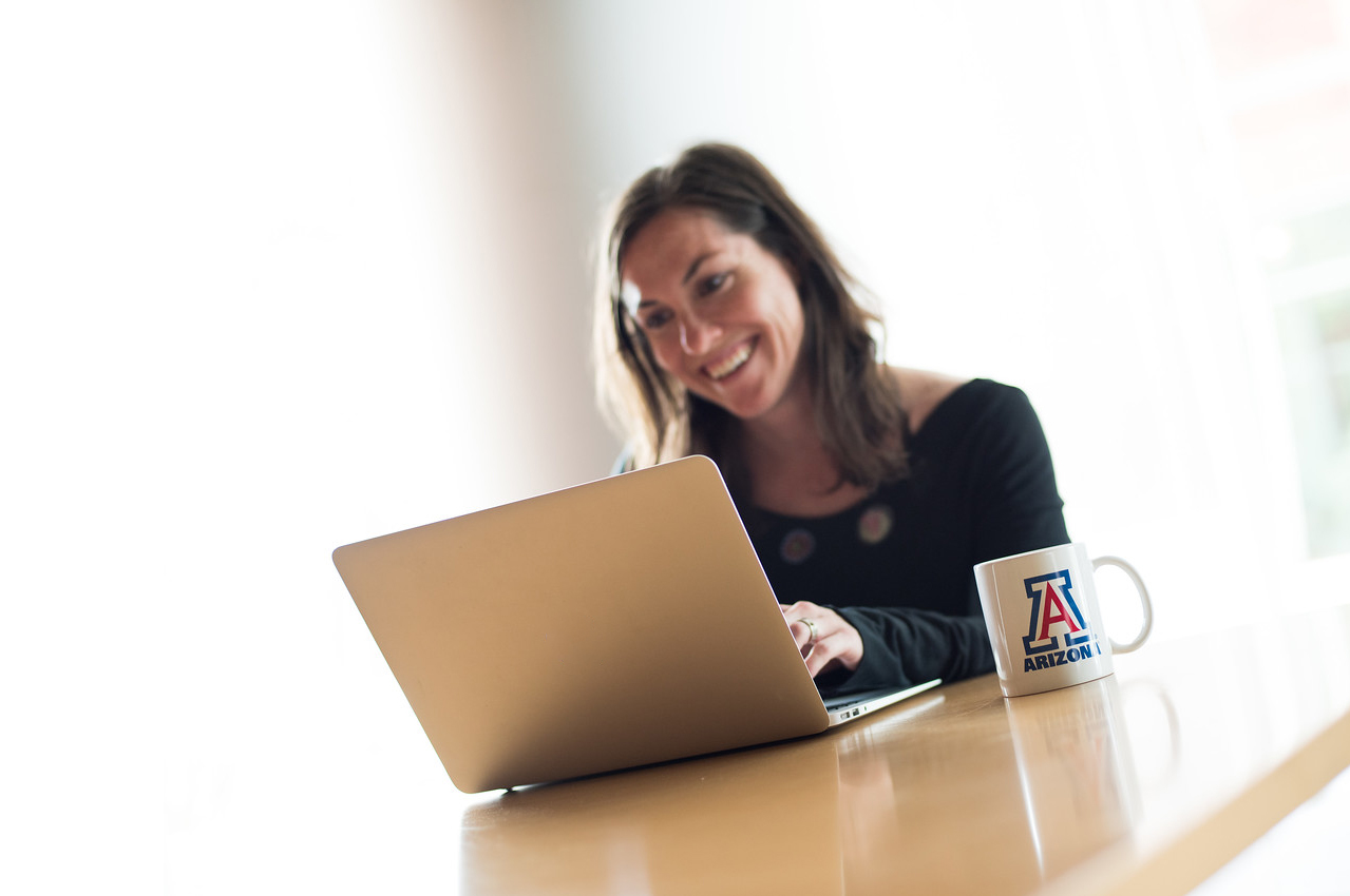 University of Arizona, woman on laptop, UArizona coffee mug