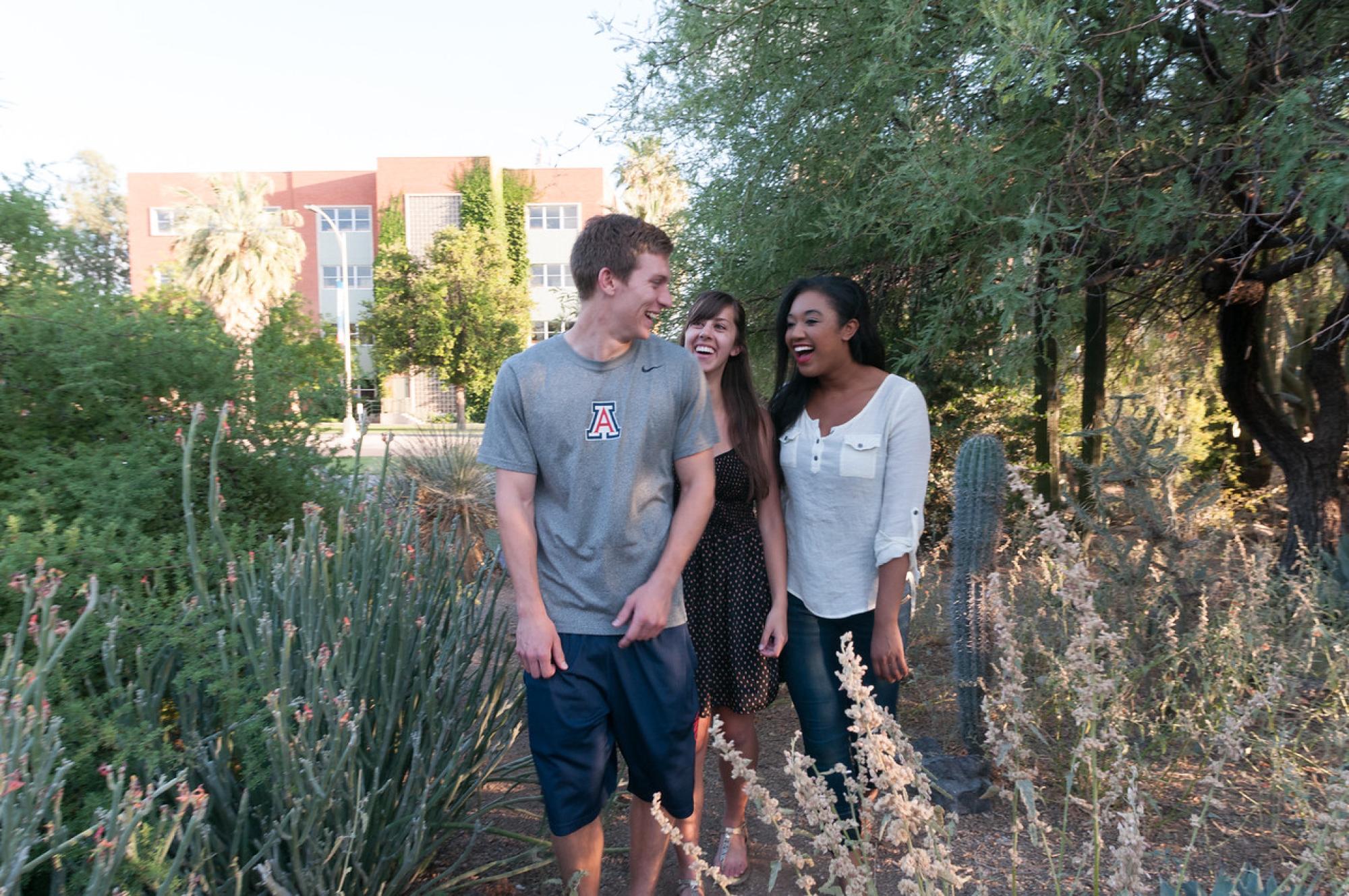 three smiling students walk through cactus garden, University of Arizona, Tucson