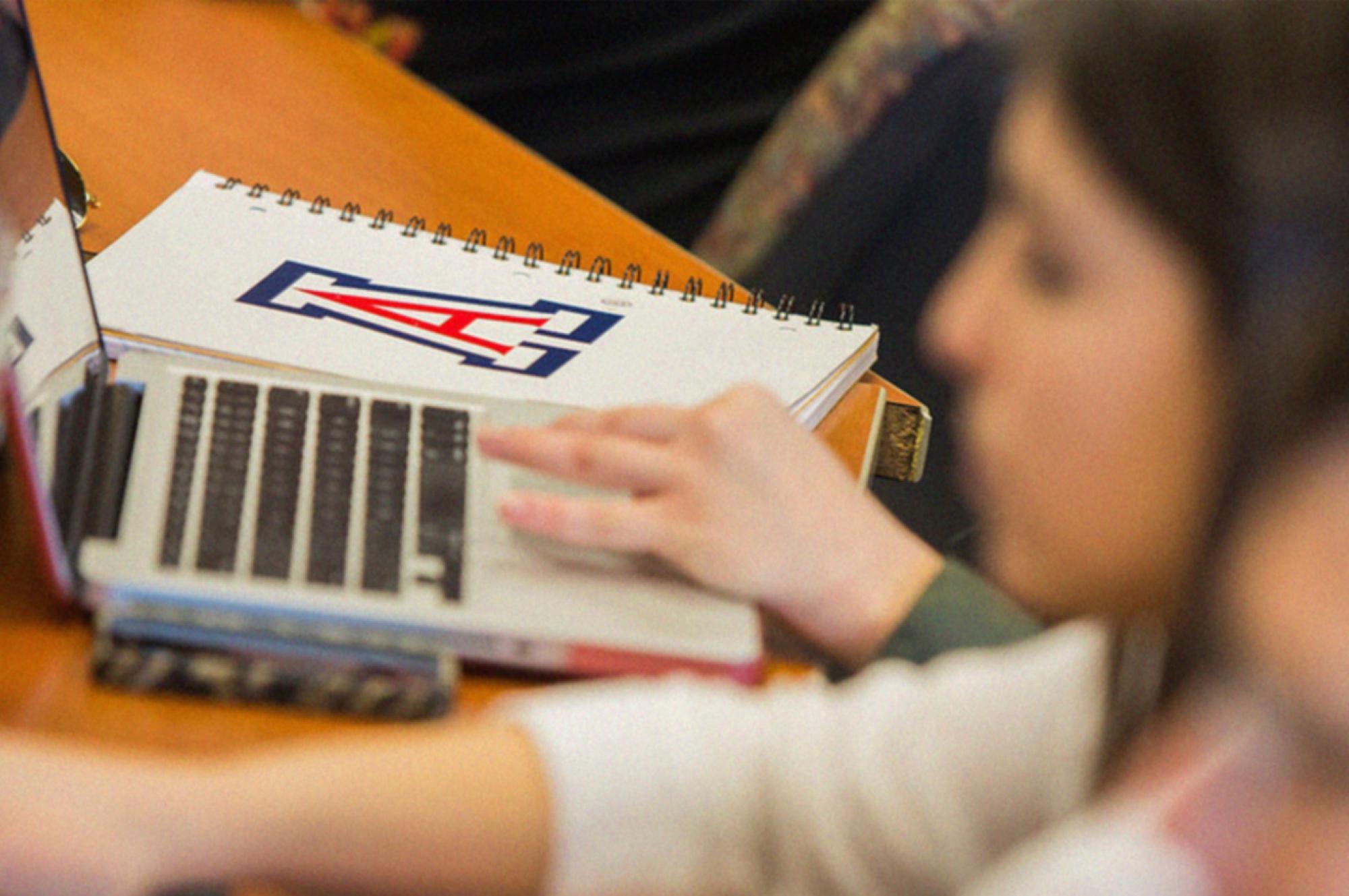 classroom with laptop and UArizona notebook